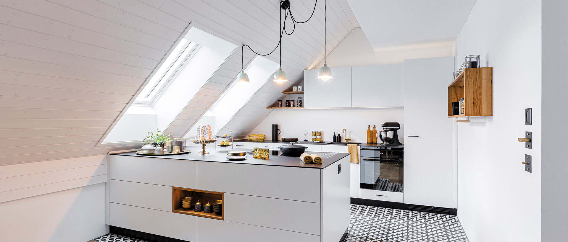 Weisse Küche mit prägnant gemusterten Bodenplatten.