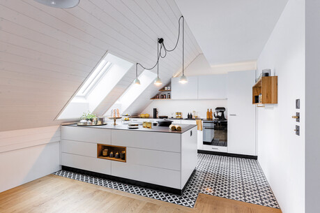 Weisse Küche mit prägnant gemusterten Bodenplatten.