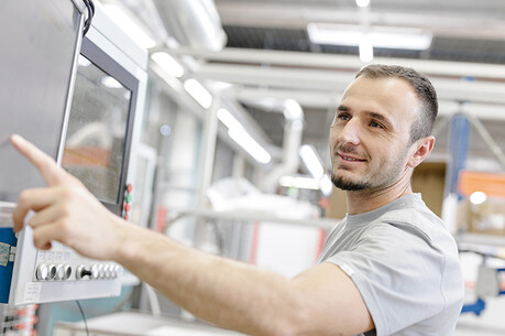 Mitarbeiter in der Produktion Ein Mitarbeiter erklärt die Maschinendaten